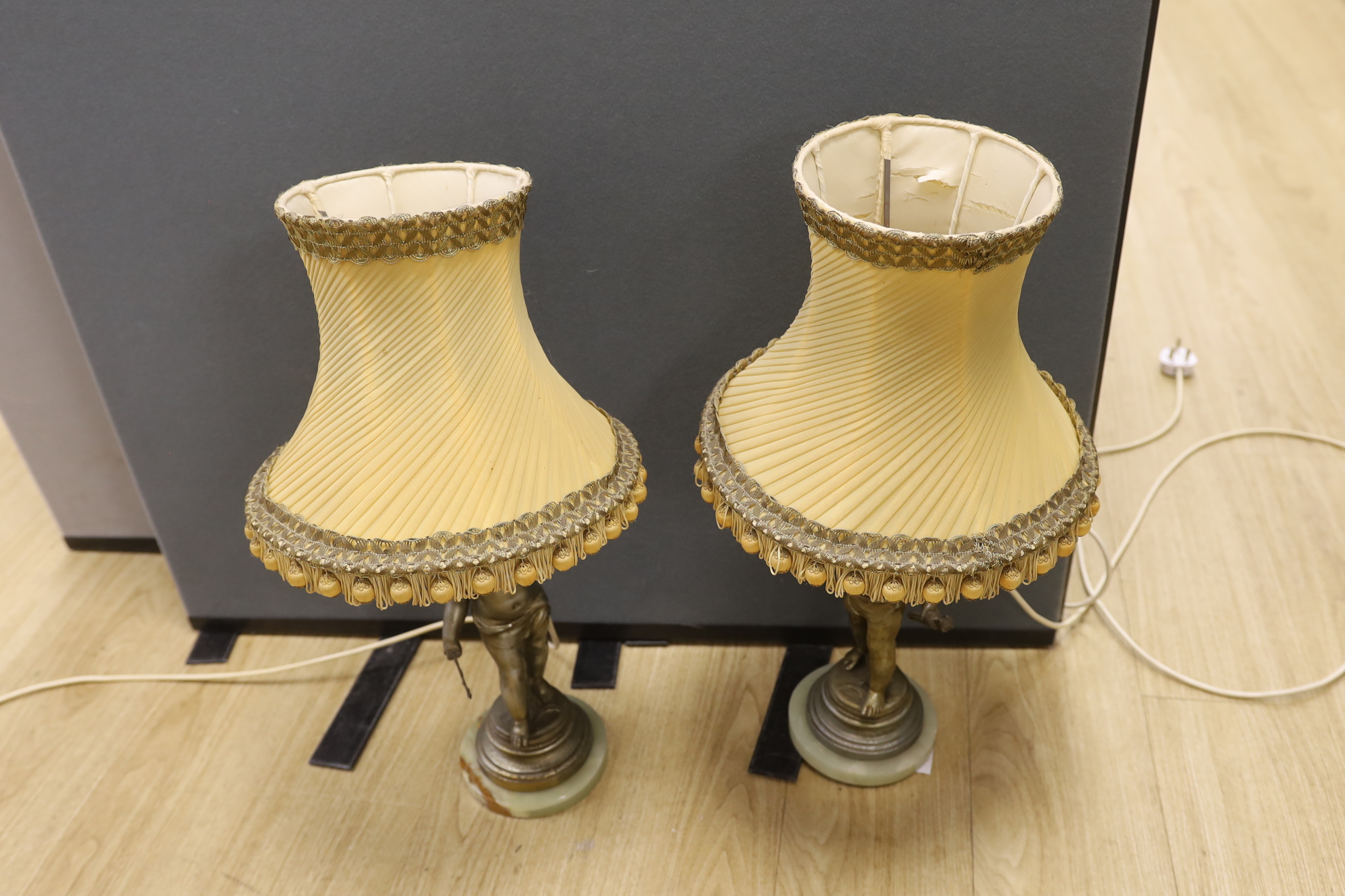 A pair of early 20th century spelter ‘cherub’ table lamps with shades, 63cm total